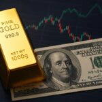 Una banconota in dollari e un lingotto d'oro con dei grafici a candele sullo sfondo